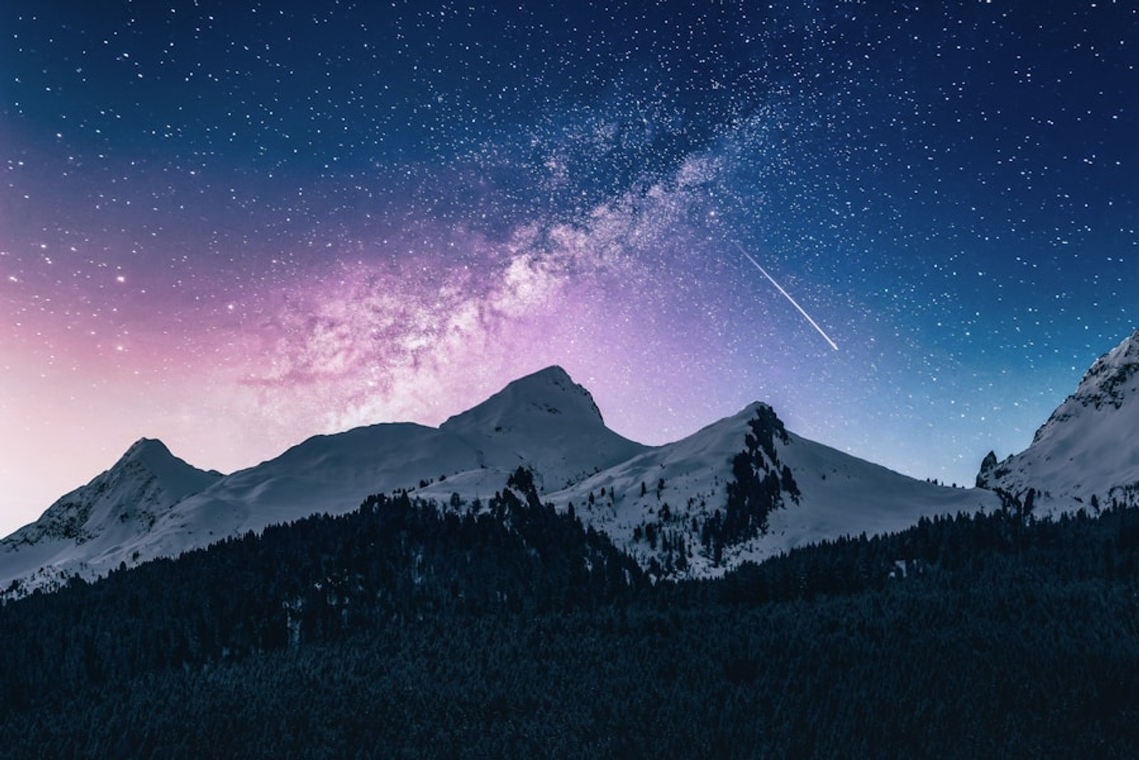 Snowy mountain beneath the Milky Way and a shooting star